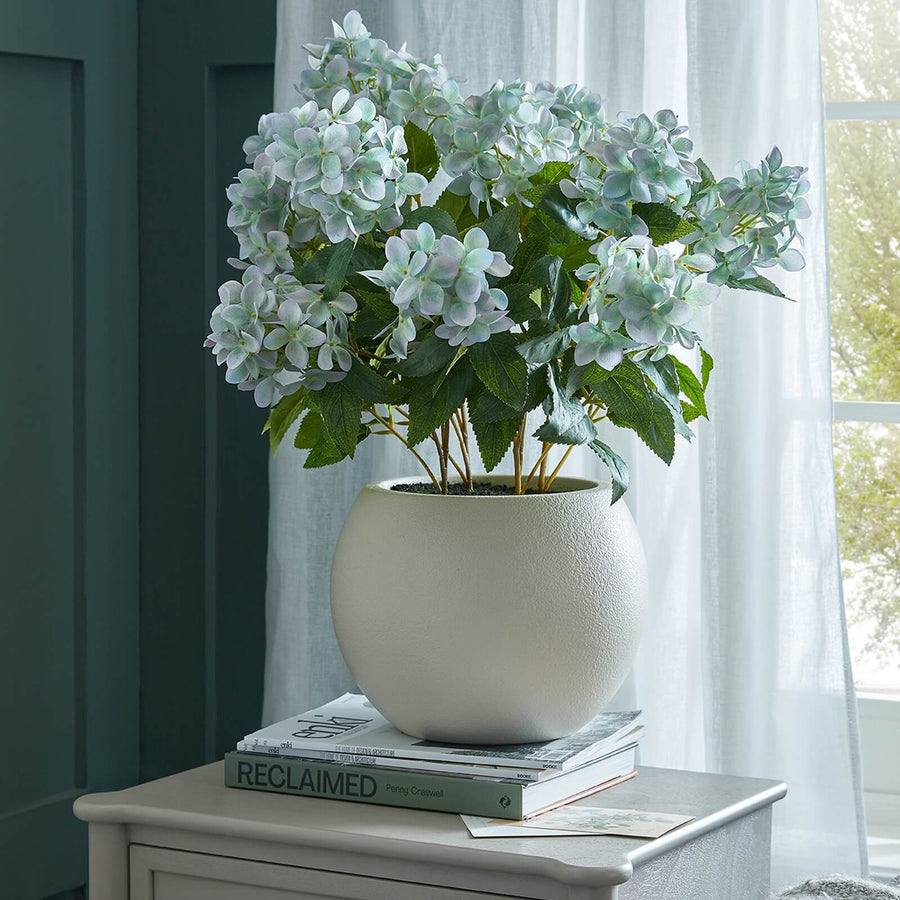 Lifelike faux Hellebore plant in vibrant green with realistic petals, potted in taupe ceramic container by Sostter at brixbailey.com