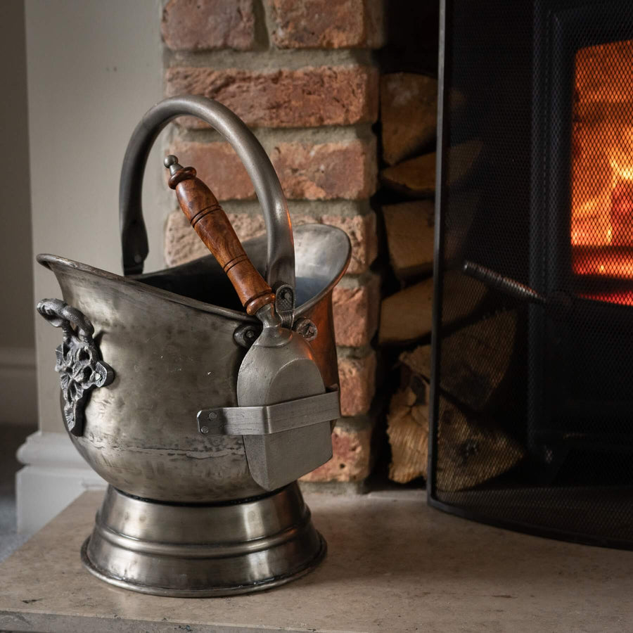 Antique pewter coal bucket and shovel set with floral embossing, rustic brown patina, and curved wooden handle for vintage decor. by Sostter at brixbailey.com