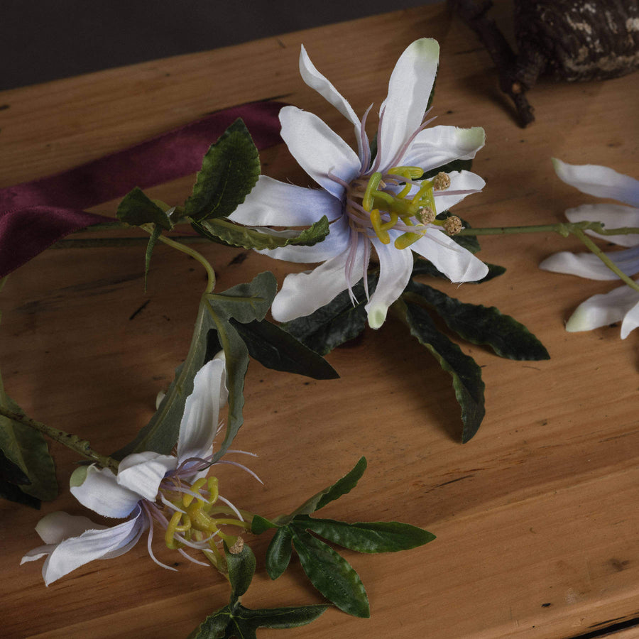 White artificial passion flower spray with verdant foliage, lifelike petals and corona filaments, 89cm home decor accent by Sostter at brixbailey.com