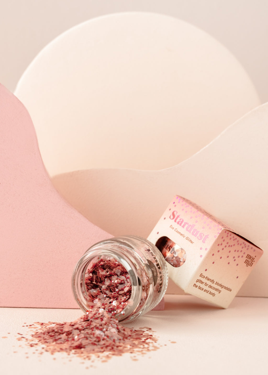 playful pink star dust glitter being sprinkled from fingers onto a sunny surface