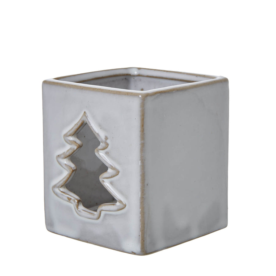 White ceramic tealight holder with intricate tree cut-outs casting shadow patterns, minimalist home decor by Sostter at brixbailey.com