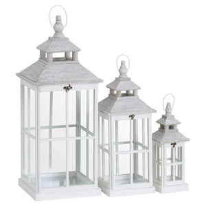 White wooden lantern with intricate window detailing, casting light patterns for coastal or Scandinavian decor. by Sostter at brixbailey.com