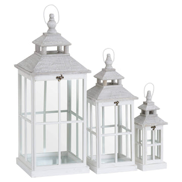 White wooden lantern with intricate window detailing, casting light patterns for coastal or Scandinavian decor. by Sostter at brixbailey.com