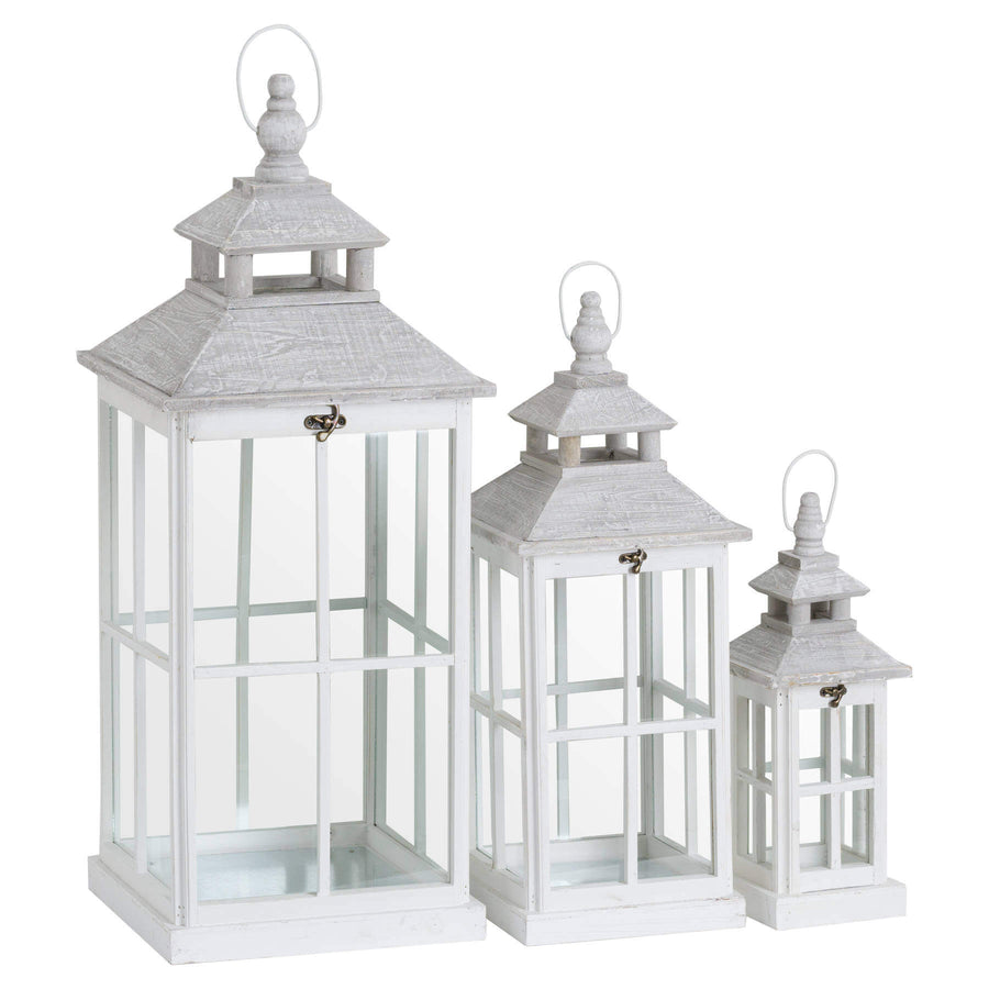 White wooden lantern with intricate window detailing, casting light patterns for coastal or Scandinavian decor. by Sostter at brixbailey.com