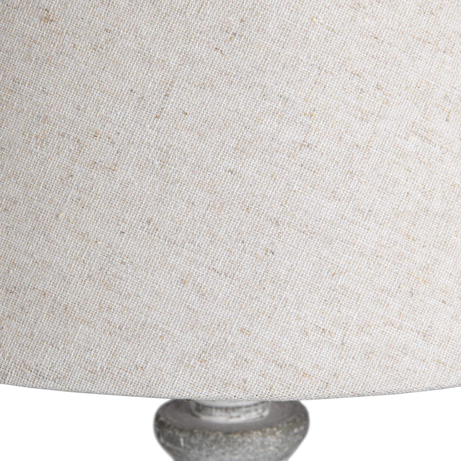 Handcrafted wooden table lamp with linen shade, warm beige finish, and artisanal carved details for cozy ambiance. by Hill Interiors at brixbailey.com