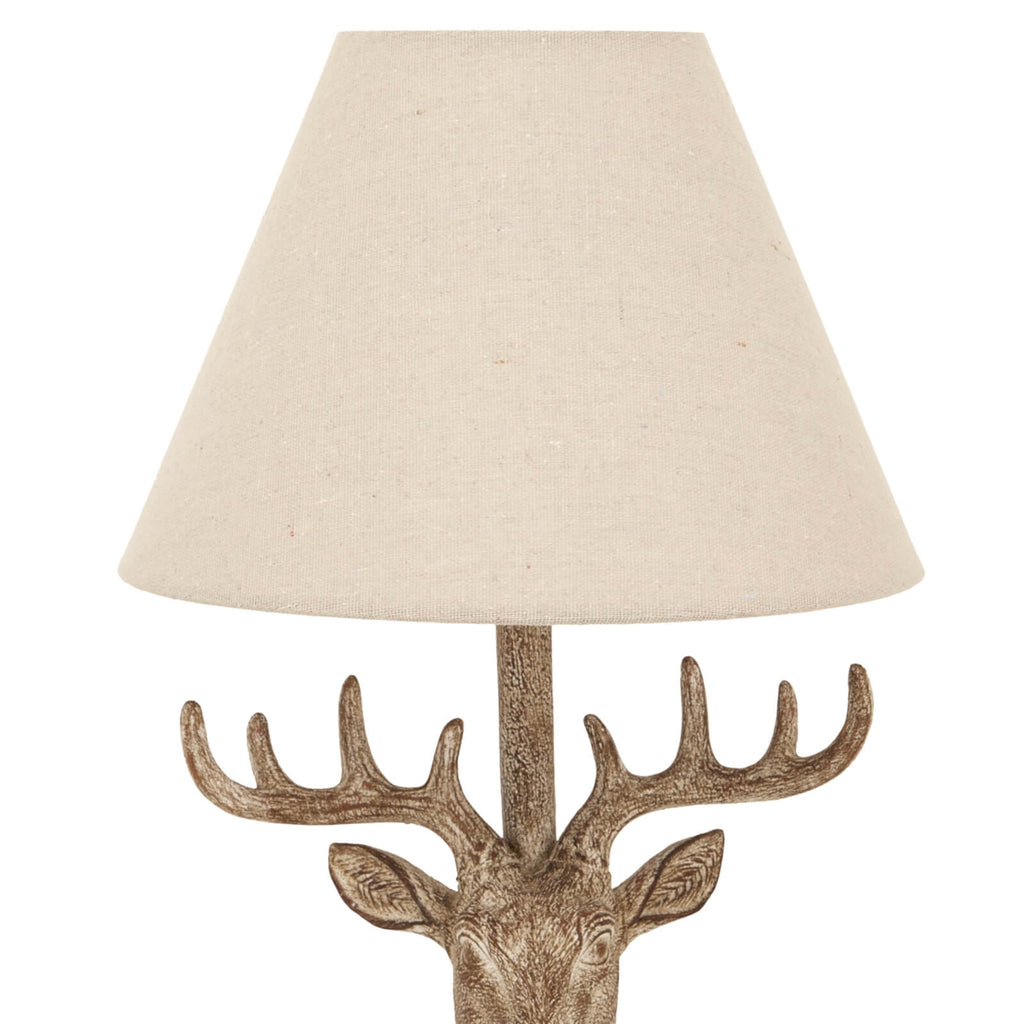 Handcrafted stag head table lamp with stonewashed resin base and natural linen shade in rich brown. by Sostter at brixbailey.com