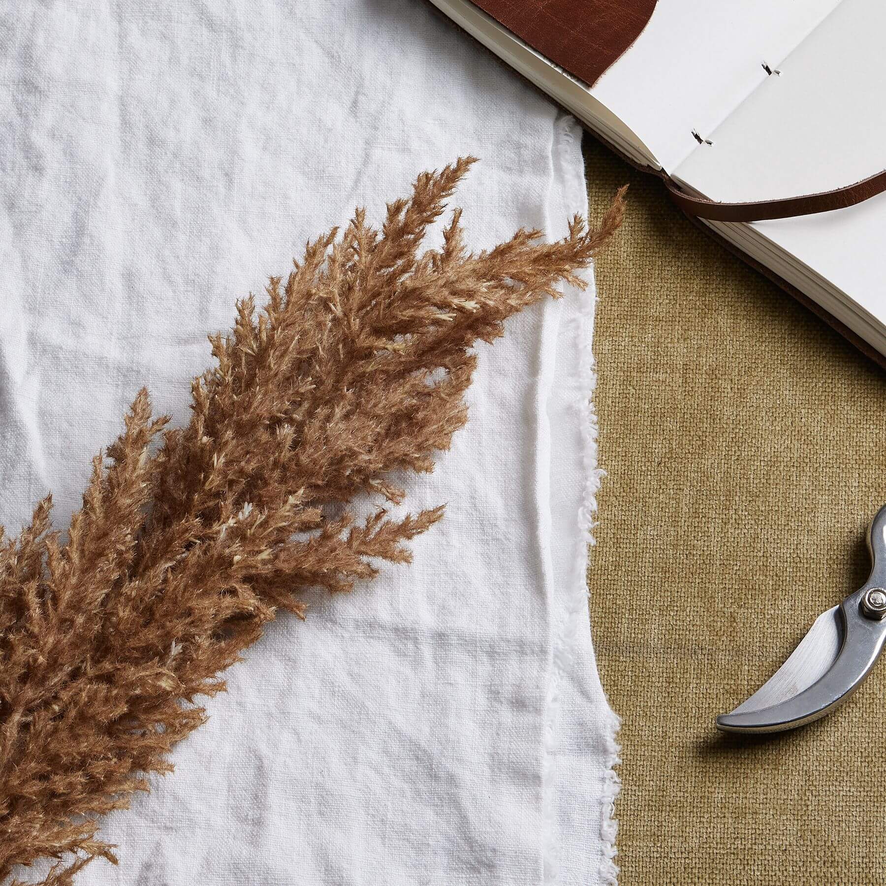 Lifelike faux pampas grass stem in soft taupe, 68cm tall, for elegant home decor with natural movement by Sostter at brixbailey.com