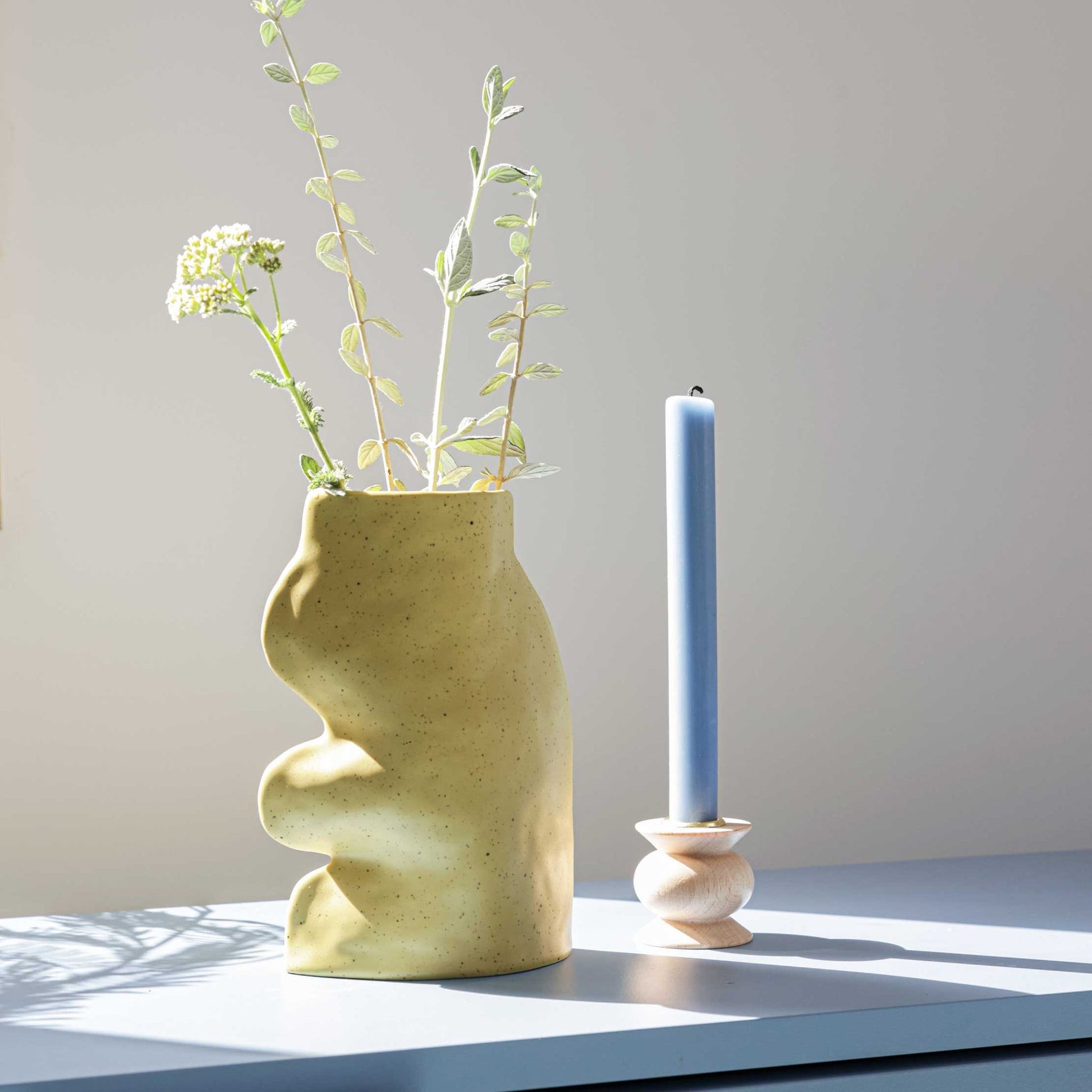 playful pistachio ceramic vase with flowing handmade lines, perfect for a vibrant shelf display