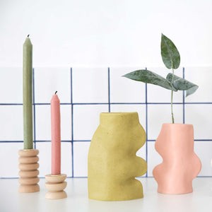 soft pistachio ceramic vase with flowing handmade lines, bathed in warm morning light on a rustic wooden table