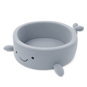 a soft dusty ice blue whale ball pit with cozy boucle fabric, bathed in gentle morning light