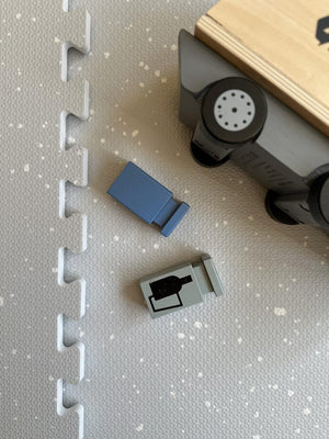 a soft dove grey baby playmat in a cozy, softly lit nursery setting