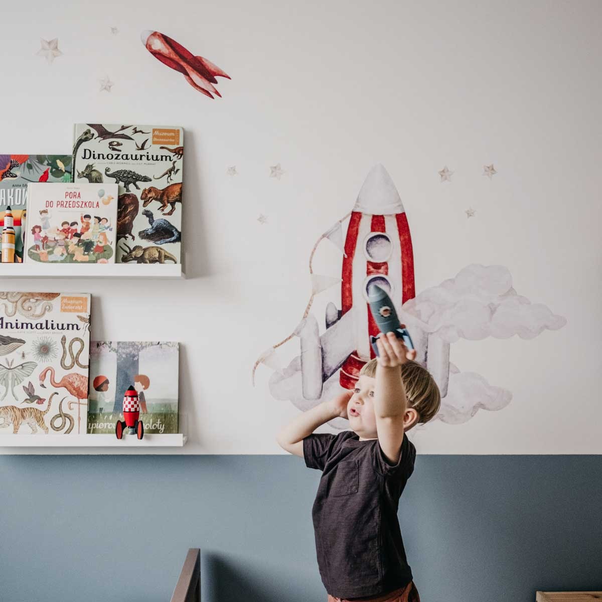 soft watercolor rocket and cloud wall stickers creating a gentle, dreamy nursery atmosphere