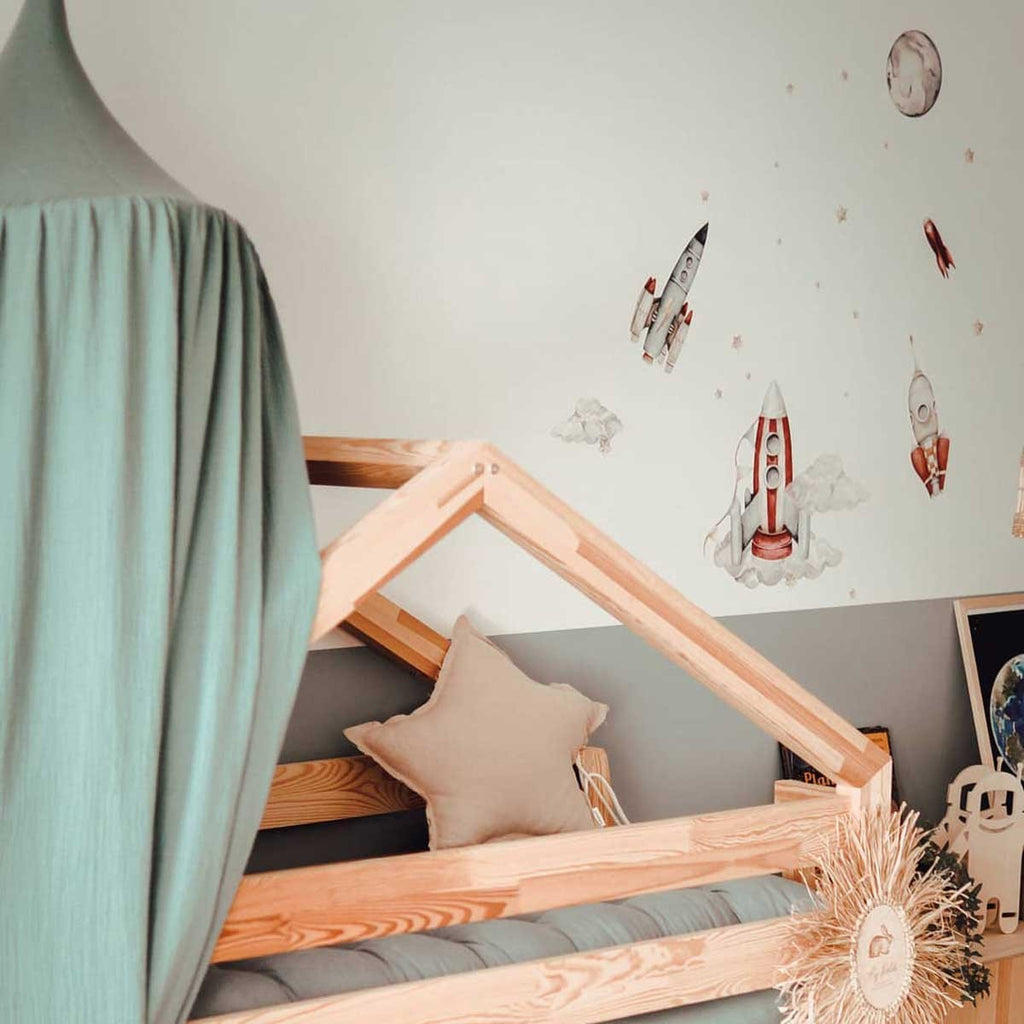 functional kids room with watercolor rocket wall stickers arranged in a practical layout above a bed