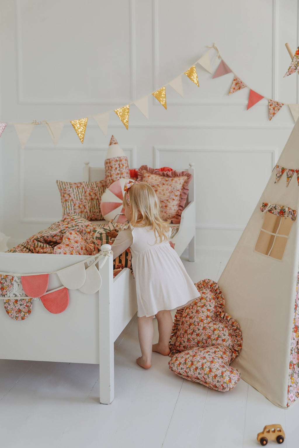 soft powder mint cotton garland draped over a wooden cradle, creating a dreamy garden birthday atmosphere