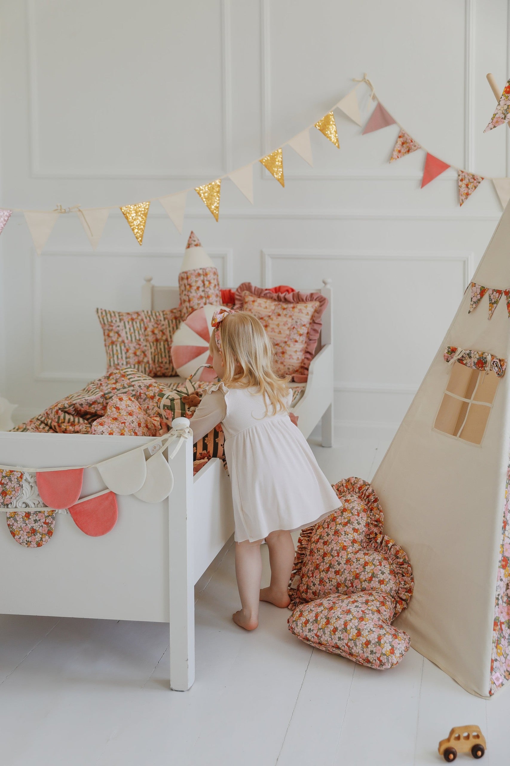 soft powder mint cotton garland draped over a wooden cradle, creating a dreamy garden birthday atmosphere
