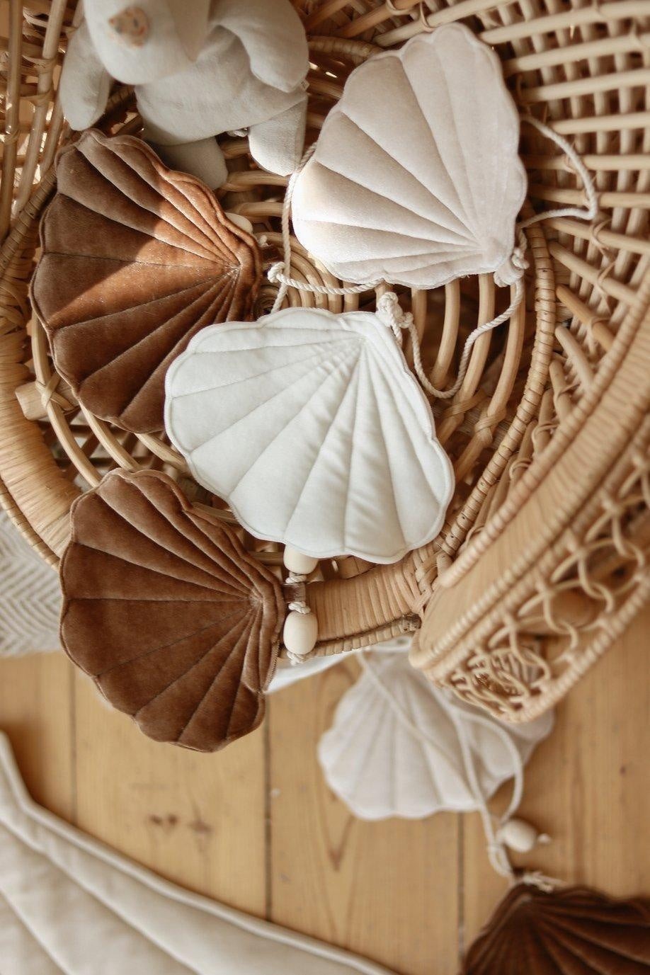 a playful close-up of the beige pearl shell garland with wooden beads, perfect for a child's whimsical reading nook