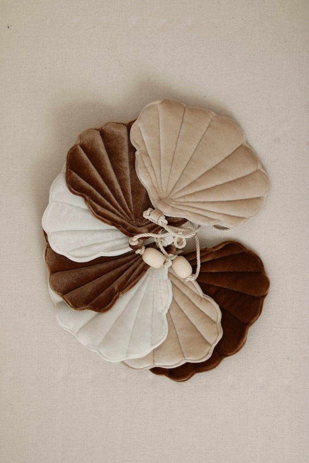 a soft-focus shot of the beige pearl shell garland draped over a rustic wooden shelf