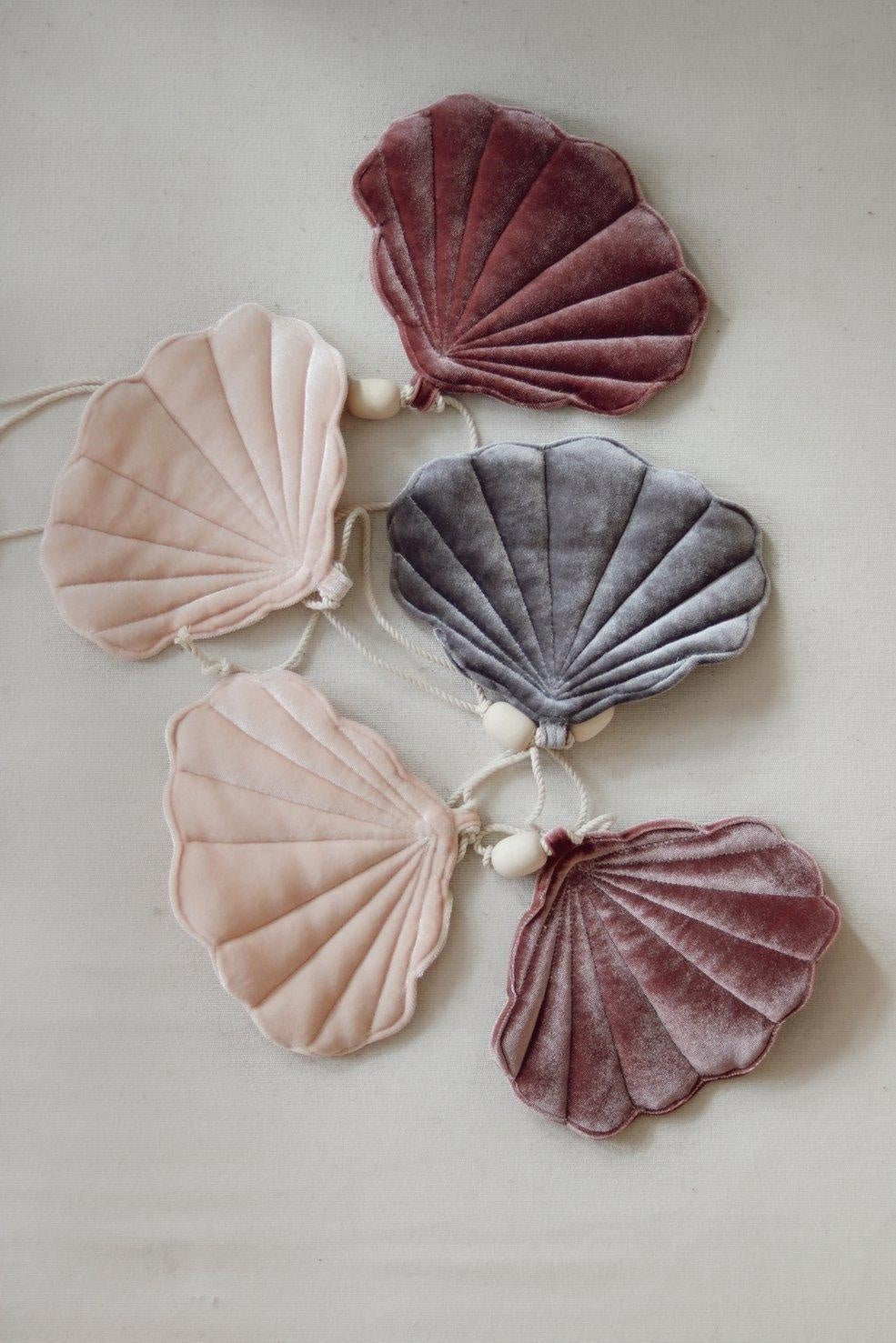 playful cosmic pearl shell garland with velvet shells and wooden beads, dangling in a sunlit kids' room