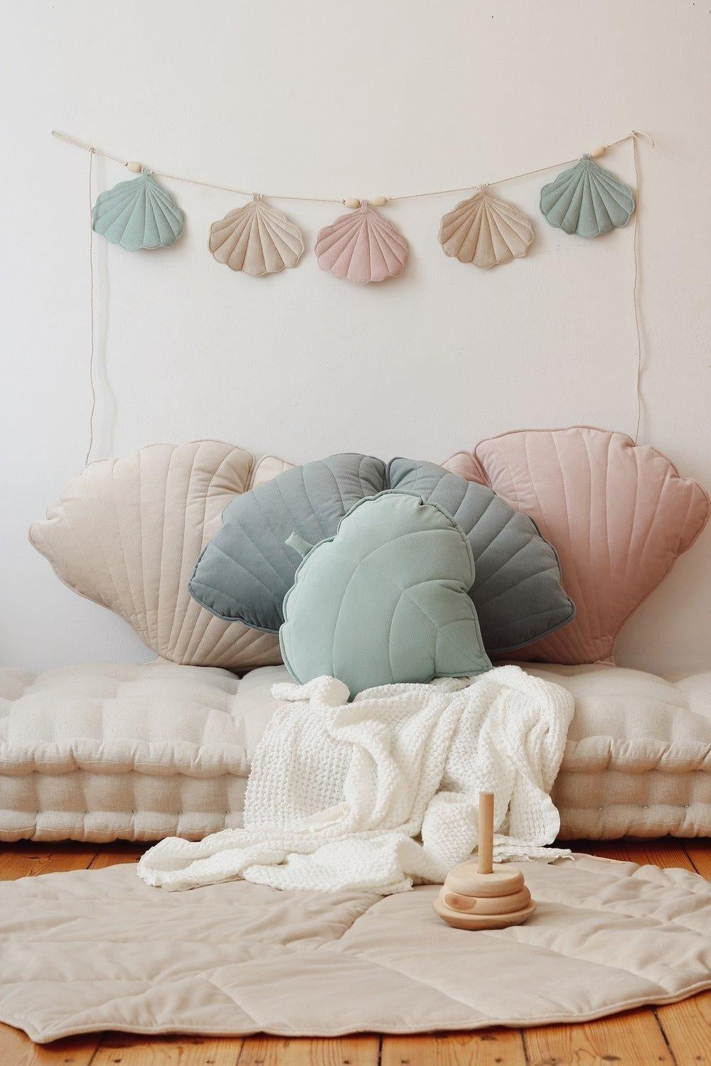 bold shell garland in late summer hues hanging against a sunlit wall, velvet pendants swaying