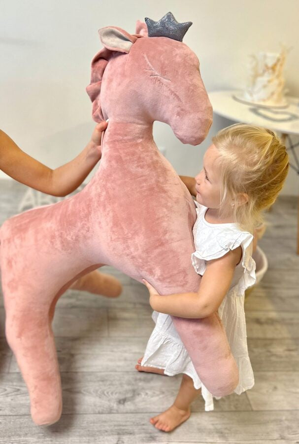 bold dusty pink velvet wingless pegasus toy in dramatic golden hour light