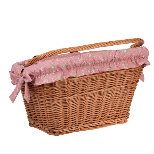 a functional handmade willow bike basket with a secure fabric liner attached to a city bike