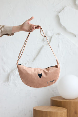 a soft cream velour hobo bag with a relaxed slouch, bathed in gentle morning light