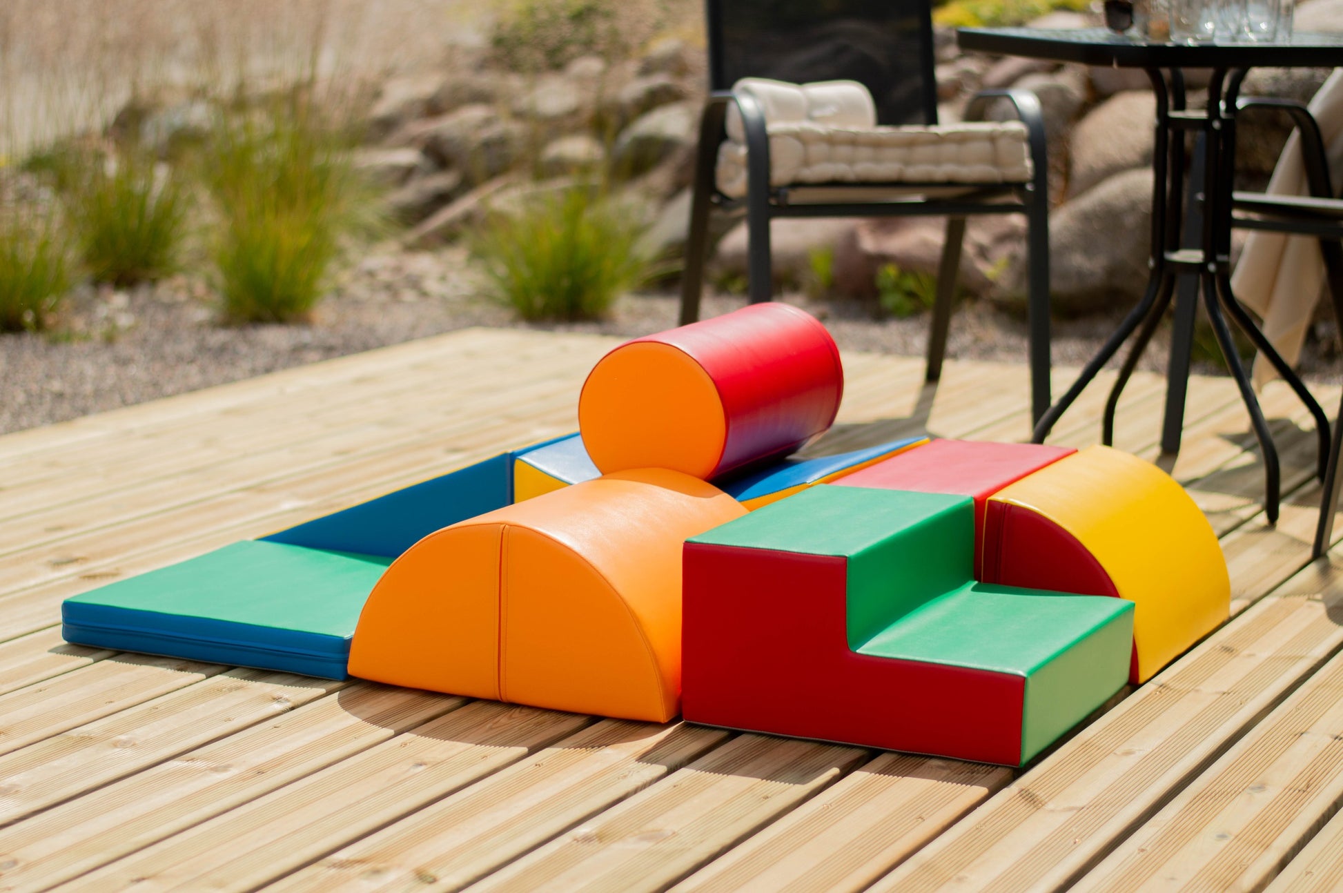 a child's hand reaching for a vibrant soft play block in a sunlit playroom