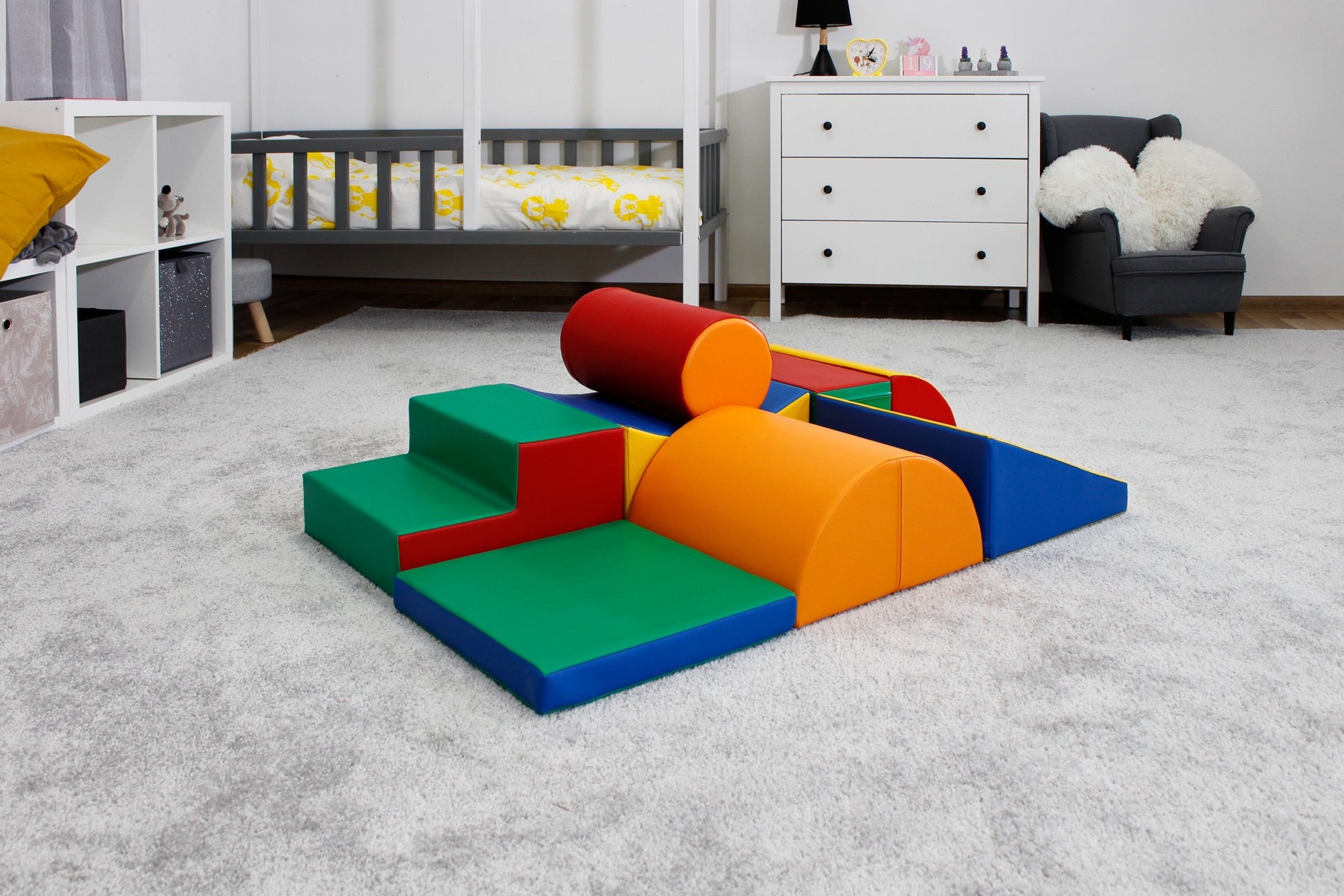 a child's hand reaching for a soft multicolor iglu play block in warm morning light