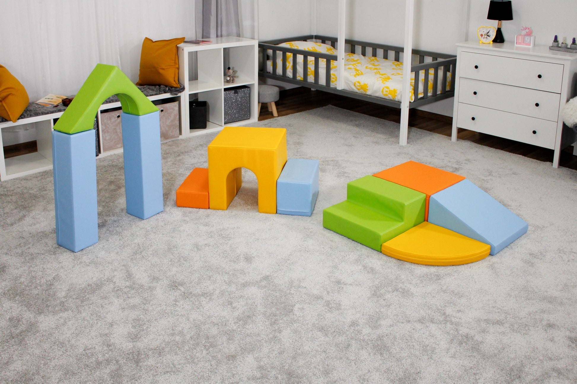 a child's hand carefully placing a vibrant iglu foam block on a colorful fort structure