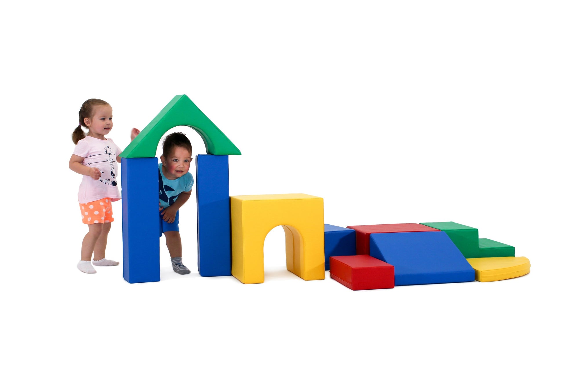 a child's hand reaching for a vibrant teal iglu foam block in a sunlit playroom