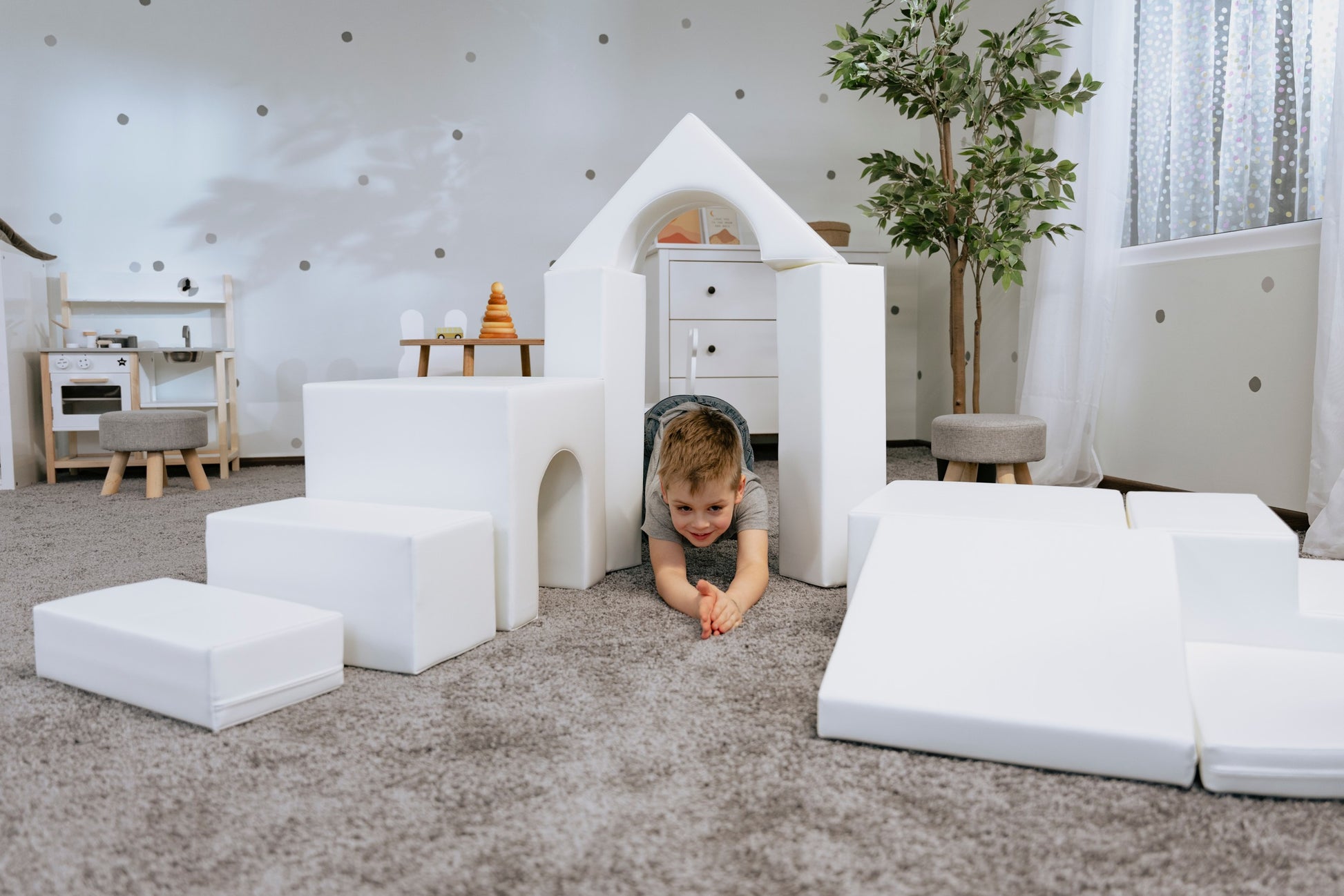 iglu soft play foam blocks stacked in a creative tower by a child