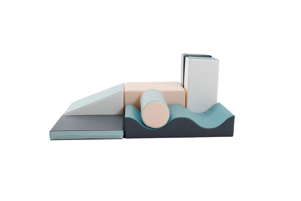 a child's hand building a soft pastel iglu block tower in a sunlit playroom