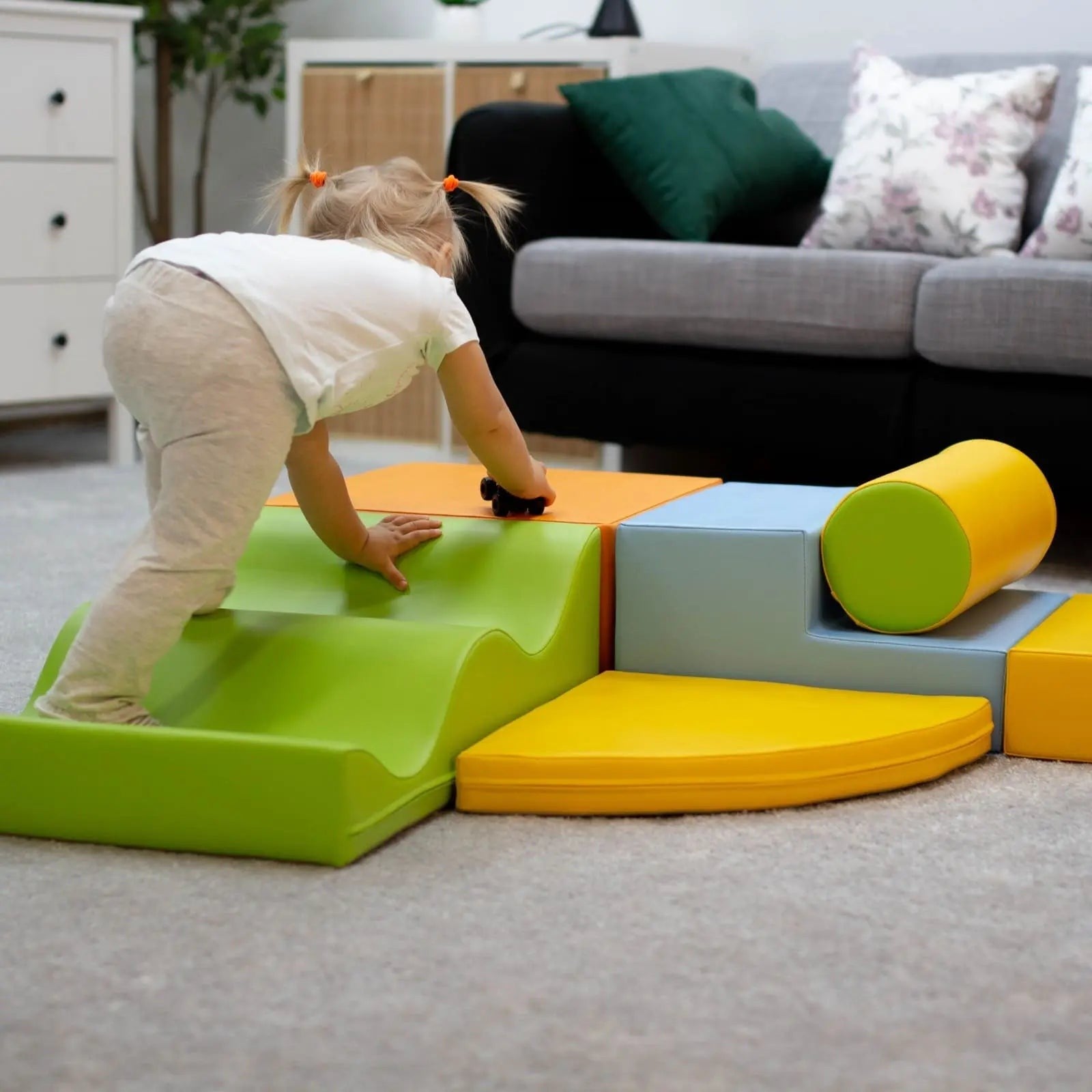 a toddler building a cozy igloo fort with soft pastel foam blocks