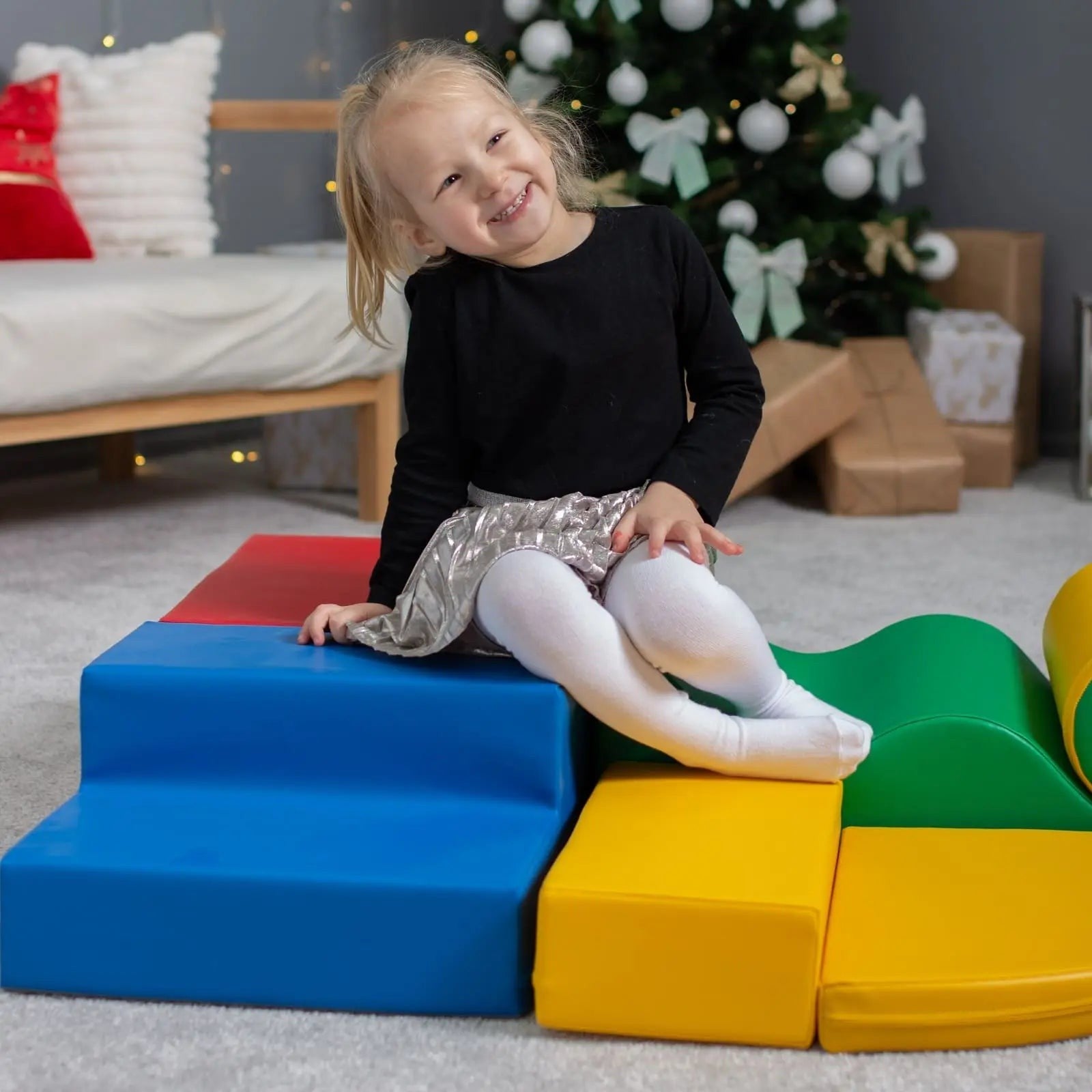 a child's hand building a vibrant iglu foam block tower in a sunlit playroom
