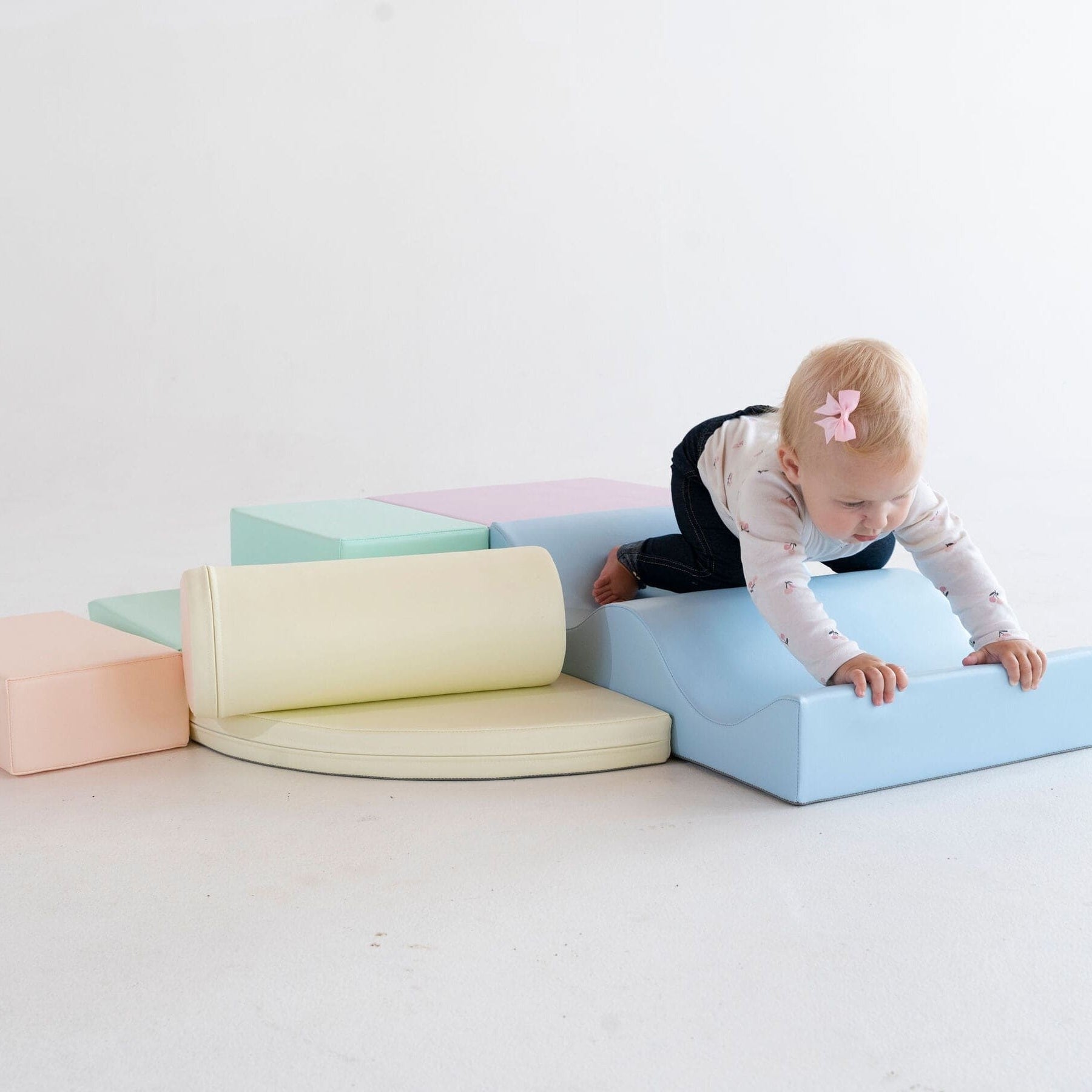a toddler building a creative pastel foam block fort for imaginative play