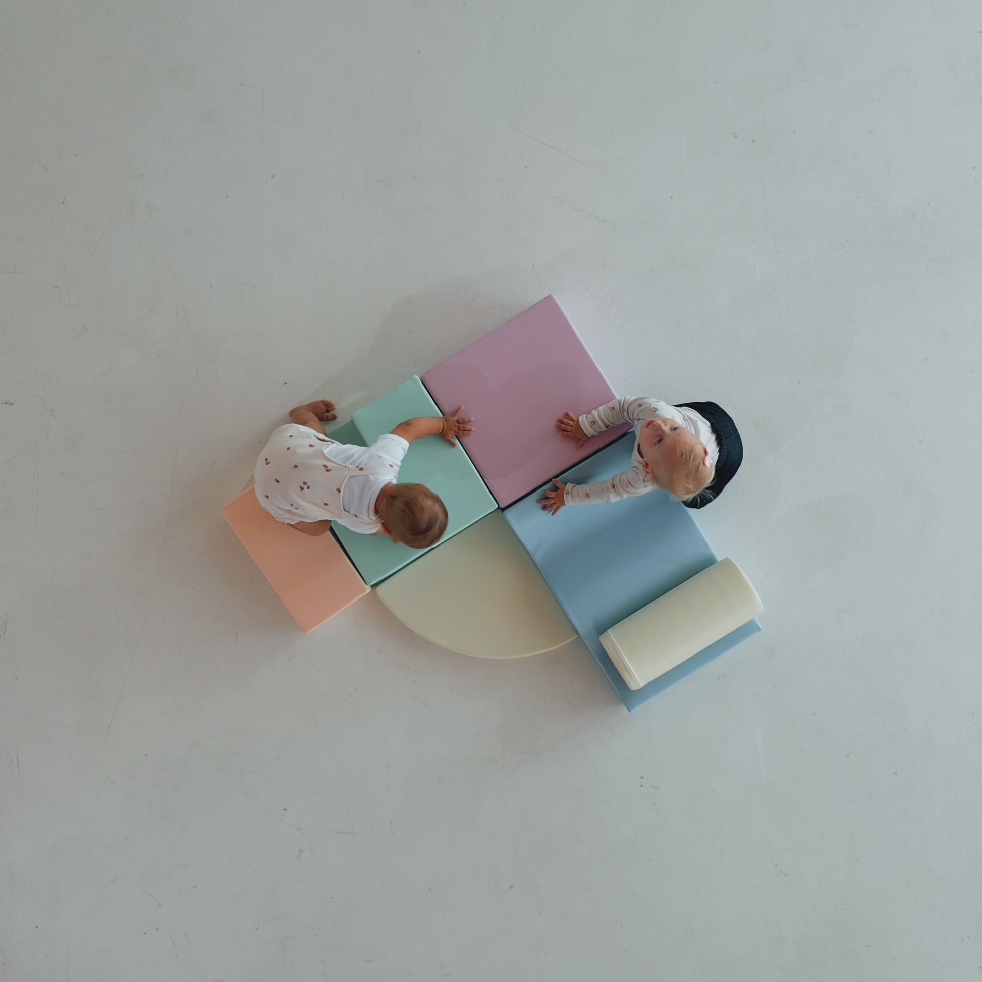 a toddler building a cozy pastel igloo fort with soft foam blocks