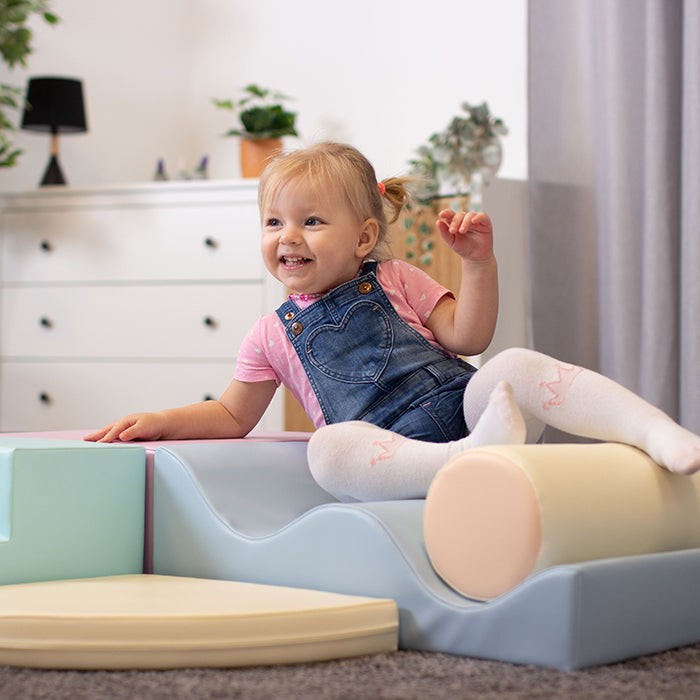 toddler building a soft pastel iglu foam block ramp in a sunlit playroom