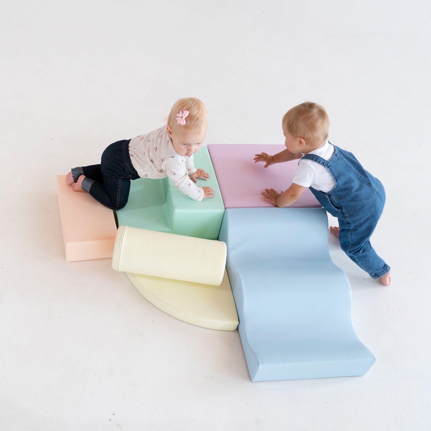 a toddler's small hands building a pastel foam block tower in a sunlit playroom