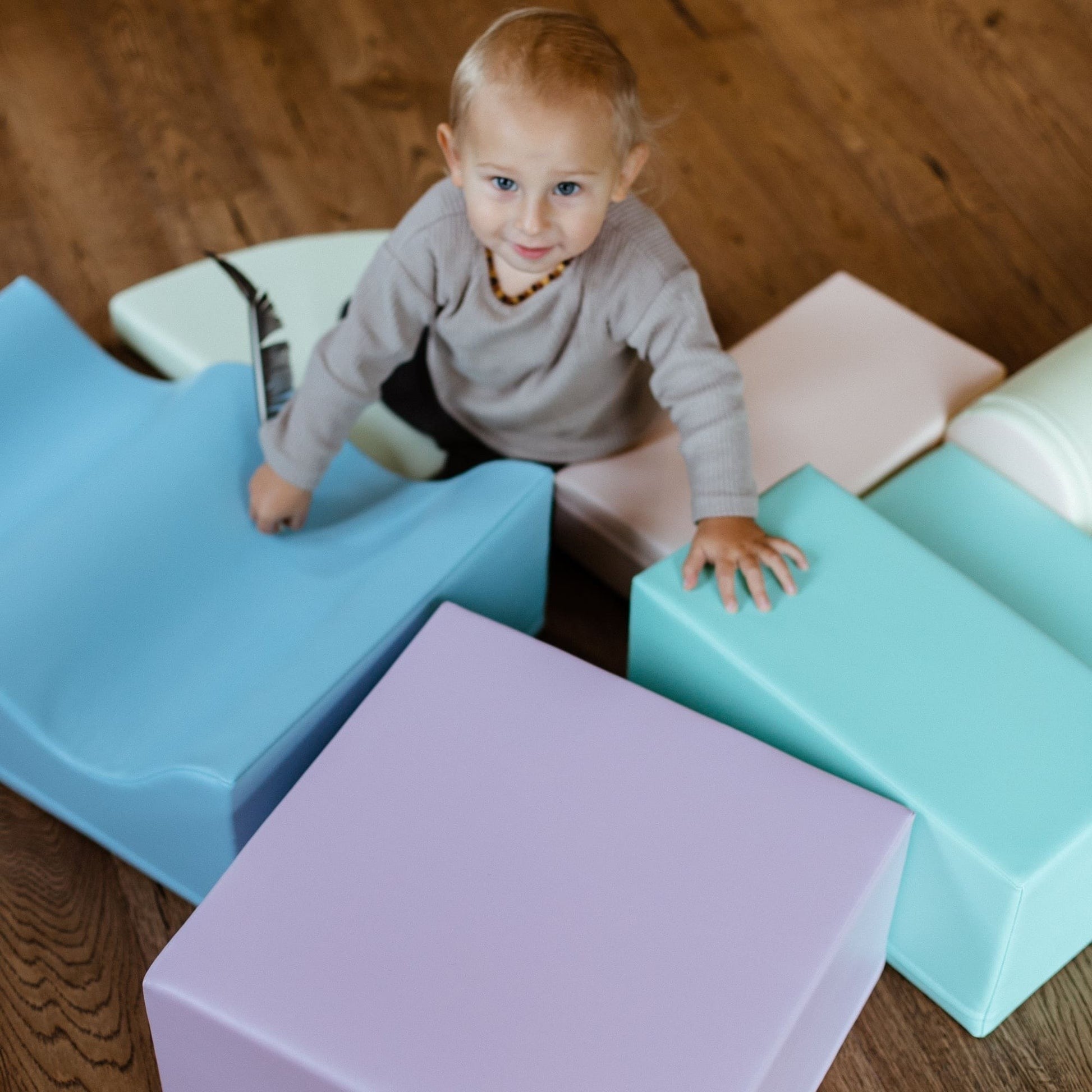 a toddler building a cozy pastel foam block fort in a sunlit playroom