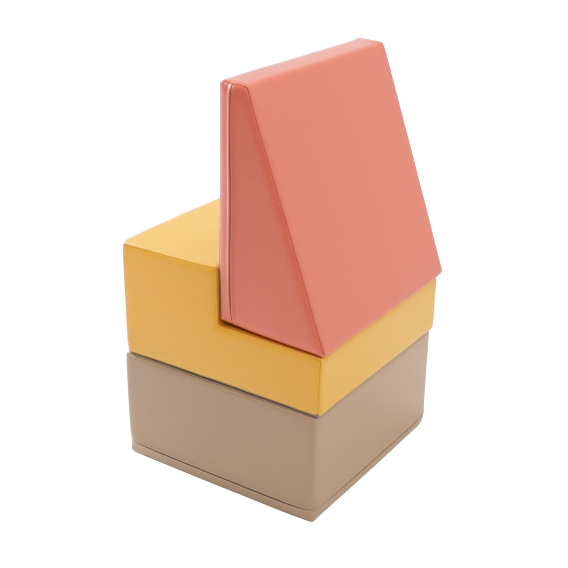 a toddler safely stacking soft pink foam blocks to build a small structure