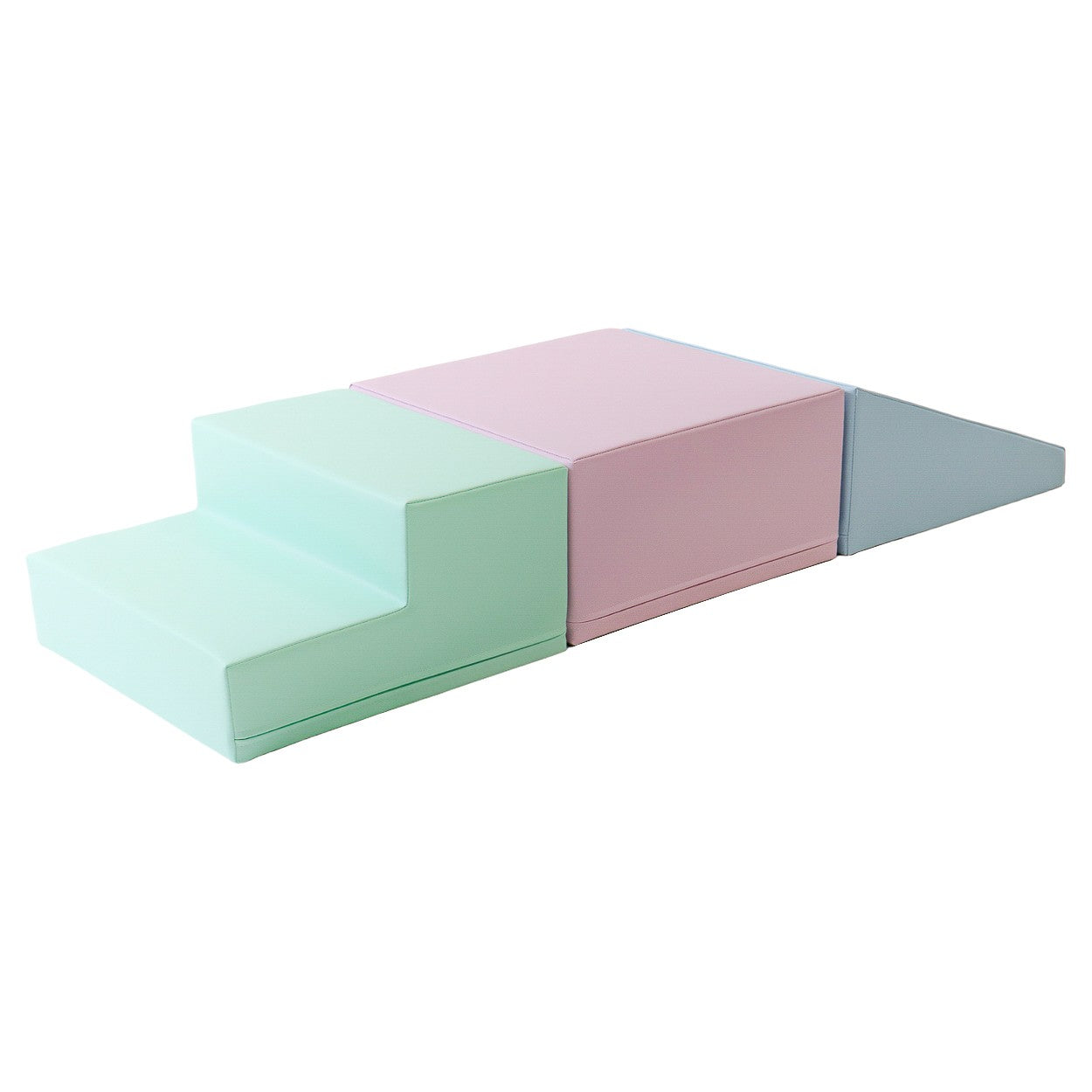 a toddler testing balance on a soft foam block set in a bright, practical playroom setting