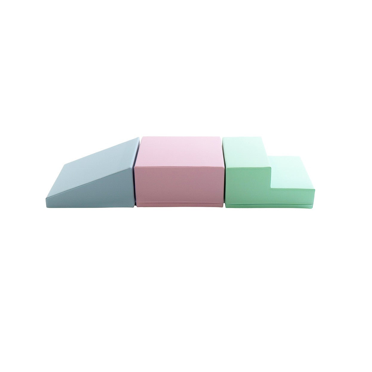 a toddler's hand gently touching a soft pastel foam block in warm morning light