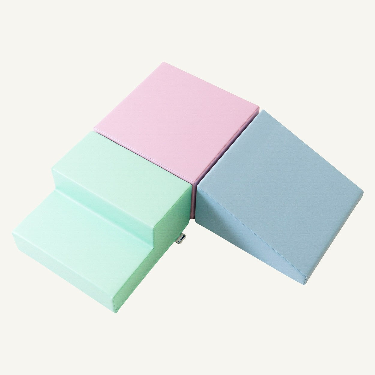 a toddler's hand touching a soft pastel foam block in warm morning light