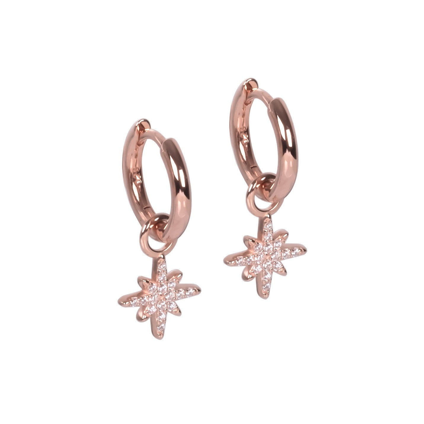 playful close-up of sterling silver star charm hoop earrings swinging freely against a soft-focus background