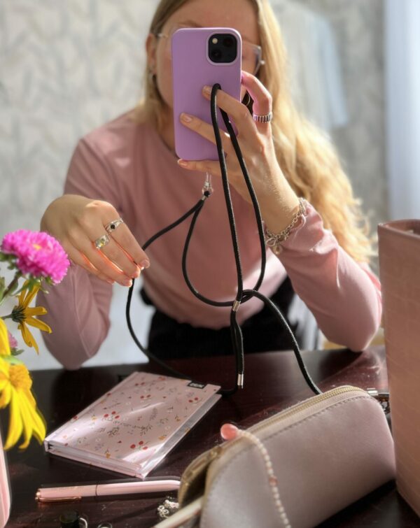 a close-up of the midnight phone strap held in a gentle hand, showcasing its soft, secure grip