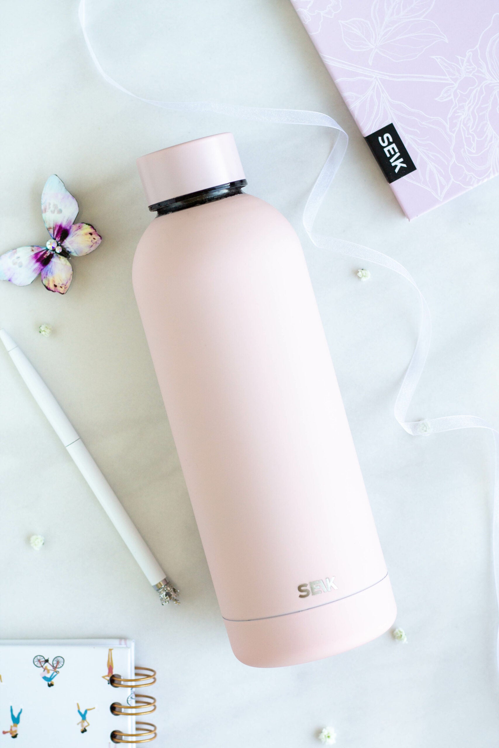 pink seik 500ml thermos on a wooden desk showing its practical leakproof cap and matte finish