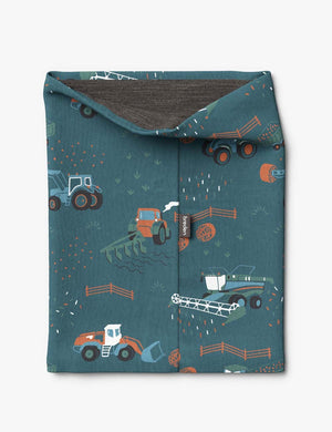 bold close-up of a kids tractor-print neck tube in morning sun