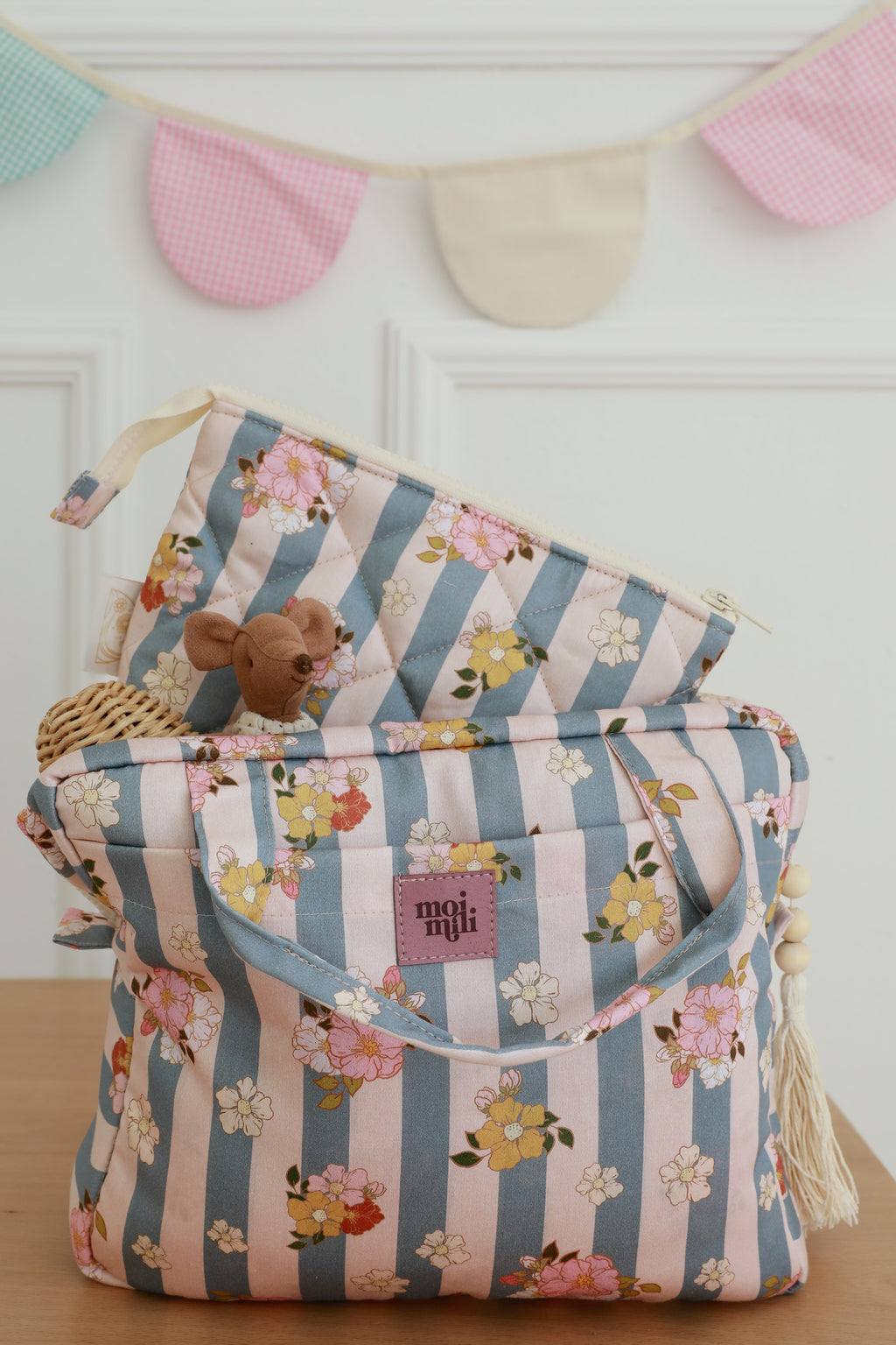 blue striped makeup bag open on a table showing its spacious interior and practical pockets