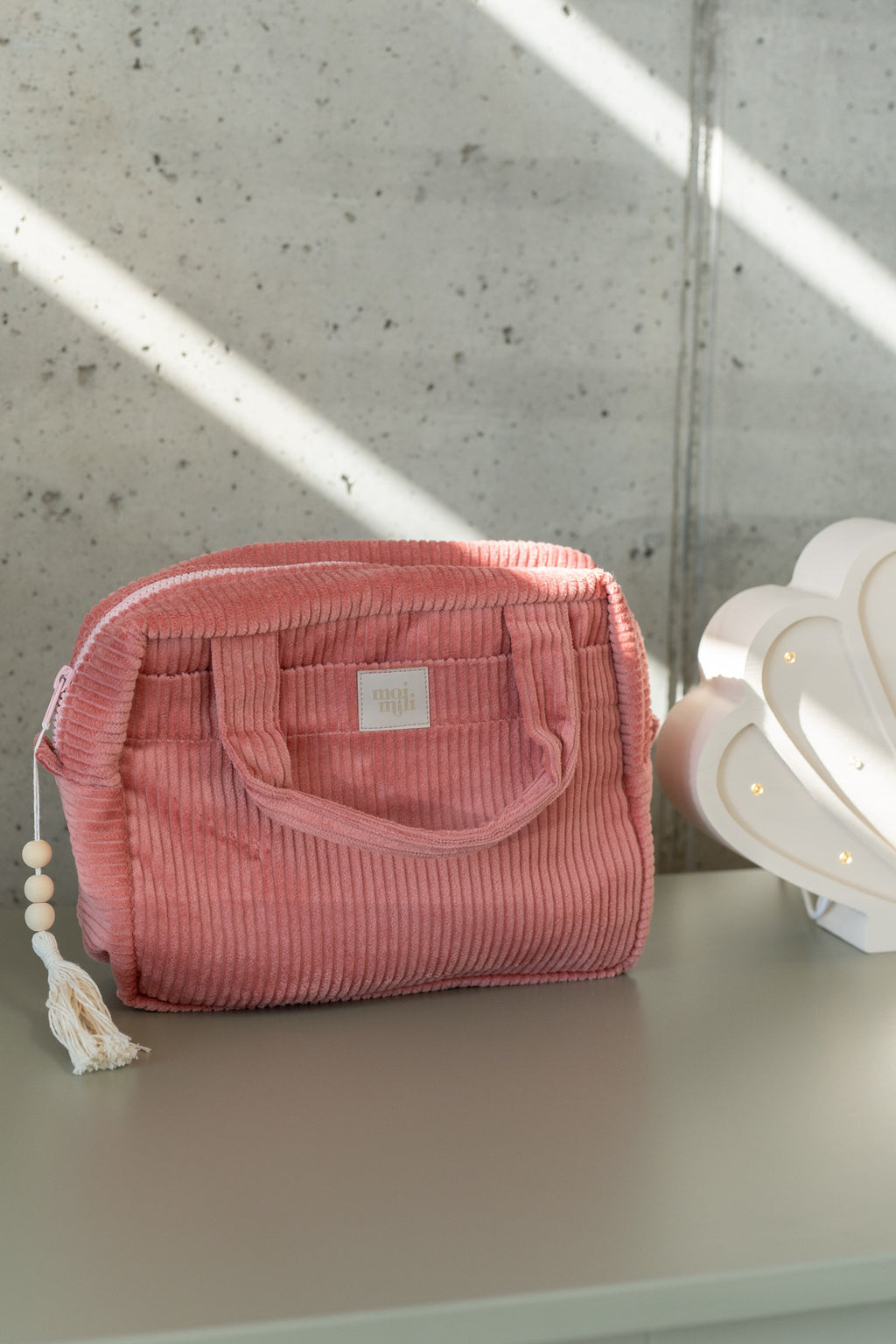 playful coral makeup bag with waterproof lining, open to show inner pockets, perfect for travel or daily use