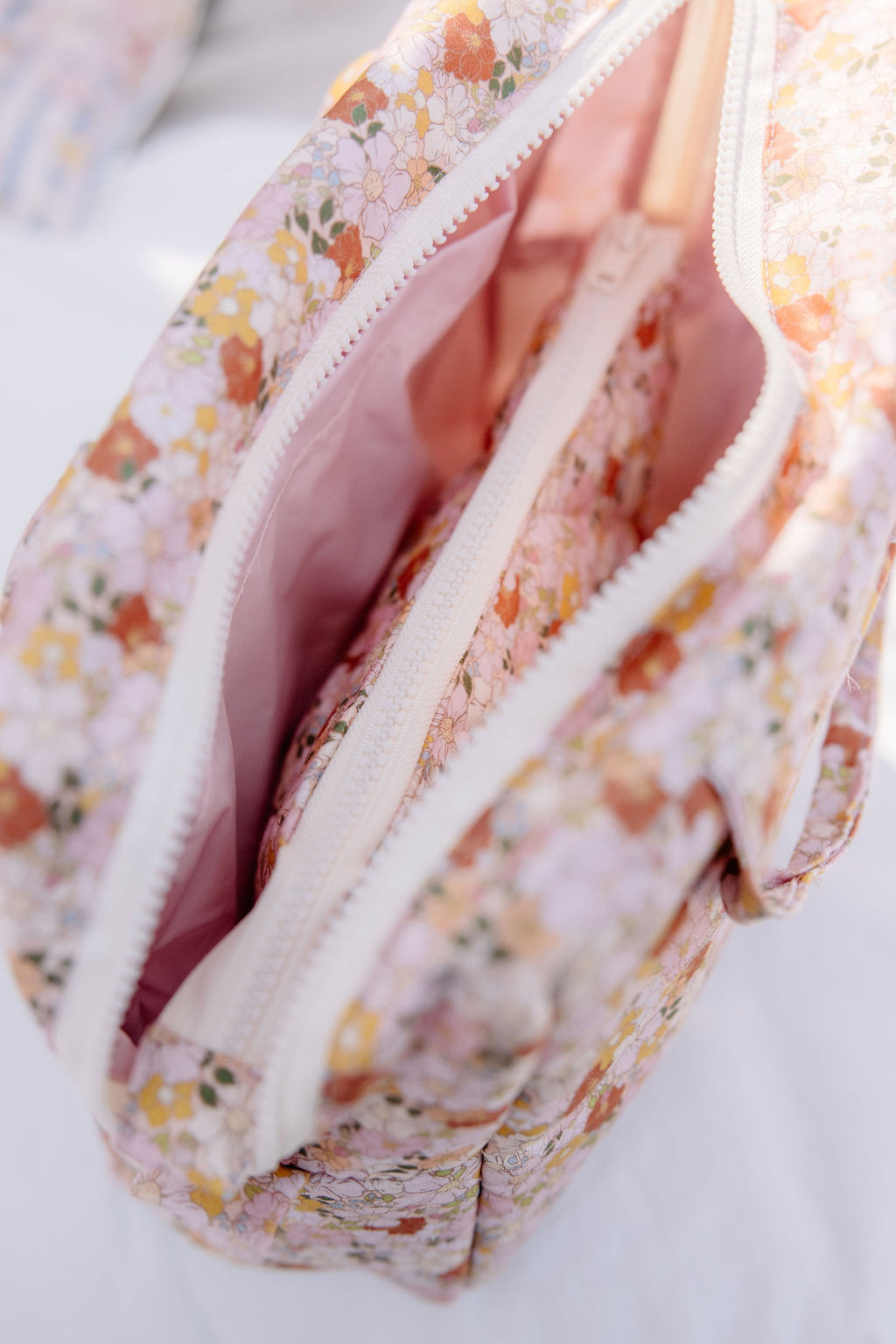elegant spring garden makeup bag with floral print, open to show waterproof lining and pockets